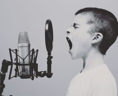 boy singing on microphone with pop filter