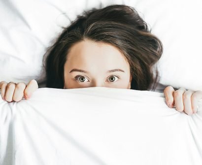 woman covering her face with blanket