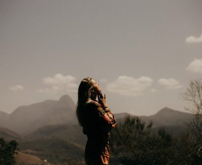 woman in black jacket standing on green grass field during daytime