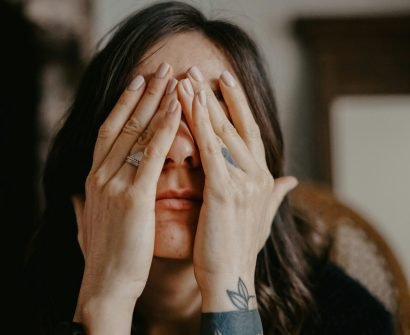 woman in black long sleeve shirt covering her face