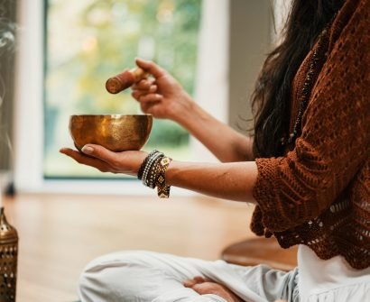 woman in brown knit sweater holding brown ceramic cup